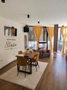 a living room with a table and chairs at Staša Apartmani in Novi Pazar