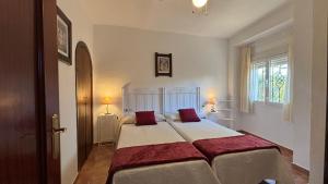 a bedroom with a large bed with two red pillows at Casa La Cañada by CasaTuristica in Ronda +36 photos