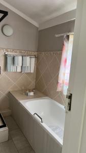 a bathroom with a bath tub and a sink at 29 Village Place in Gaborone +15 photos