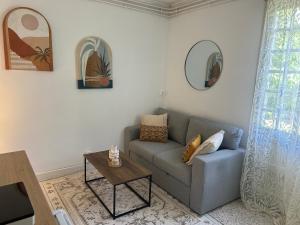 a living room with a couch and a table at Le Petit Rocher in Pierrelatte