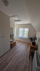 an empty living room with wooden floors and a window at The Wimpey At Mill Cottage in Bedford