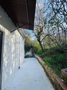 a walkway next to a white wall with a roof at Gaias Hideway in Áno Vlasía