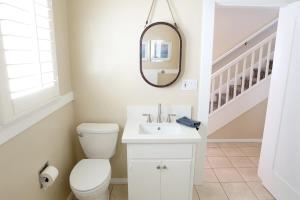 a bathroom with a toilet and a sink and a mirror at 1400 South Bayfront in Newport Beach +39 photos