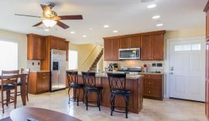 a kitchen with wooden cabinets and a bar with bar stools at 209 38th St. B Condo in Newport Beach