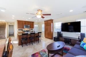 a living room with a ceiling fan and a kitchen at 209 38th St. B Condo in Newport Beach