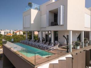 an external view of a house with a swimming pool at Dedaj Resort - Penthouse Auri in Zadar