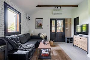 a living room with a couch and a tv at Bodony Cottage in Bodony