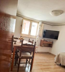 a dining room with a table and a tv at La dimora di nonna Giuseppa in Pachino