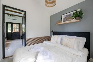 a bedroom with a bed with white sheets and a mirror at Bodony Cottage in Bodony