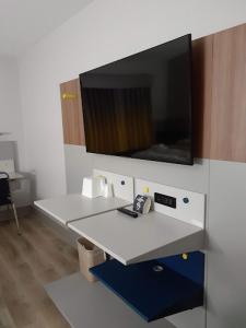 a room with a counter with a tv on the wall at Micro Hotel in Conyers +4 photos