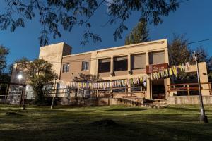 a building with prayer flags in front of it at Hostería La Cascada in Alpa Corral