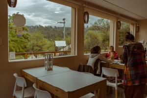 a group of people sitting at a table in a restaurant at Hostería La Cascada in Alpa Corral