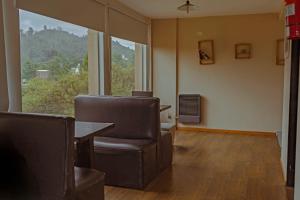 an office with chairs and a table and a large window at Hostería La Cascada in Alpa Corral