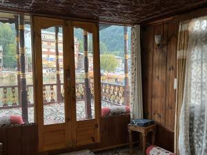a room with a balcony with a large glass door at FREEDOM houseBoat in Srinagar +9 photos