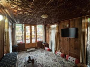 a bedroom with a tv on the wall and a room with at FREEDOM houseBoat in Srinagar