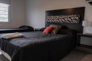a bedroom with a bed with a black headboard at Hostería La Cascada in Alpa Corral