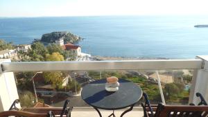 a table on a balcony with a view of the ocean at Cavo D' Oro in Piraeus