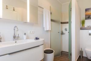 a white bathroom with a sink and a toilet at FeWo Sanfte Brise im EG mit Blick in die Natur in Göhren-Lebbin +20 photos