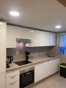 a kitchen with white cabinets and a sink and a window at Hilton Tanger View Tower 15D in Tangier