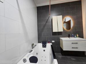 a bathroom with a white sink and a white bath tub at Admiralty in Araromi