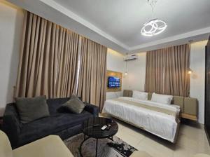 a hotel room with a bed and a couch at Admiralty in Araromi