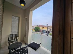 a balcony with a table and chairs and a large window at Admiralty in Araromi