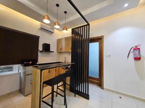 a kitchen with a counter and a bar with a chair at Admiralty in Araromi