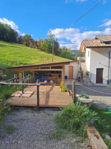 a house with a wooden deck next to a building at Agriturismo Cascina Lella in Varzi