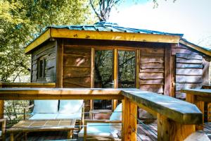 a log cabin with a porch and a deck at Cabane perchée in Puylaurens