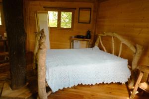 a bedroom with a bed in a log cabin at Cabane perchée in Puylaurens