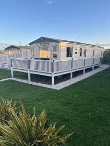 a large white house with a porch and a yard at Fairway by the sea in Newbiggin-by-the-Sea