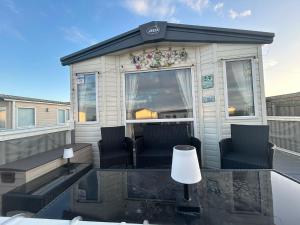 a tiny house with two chairs and a table at Fairway by the sea in Newbiggin-by-the-Sea
