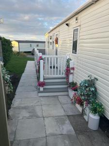 a house with a porch and stairs with flowers at Fairway by the sea in Newbiggin-by-the-Sea
