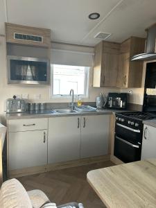 a kitchen with a sink and a stove top oven at Fairway by the sea in Newbiggin-by-the-Sea