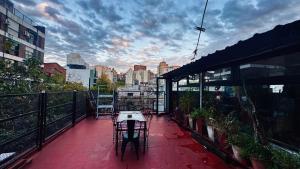 a patio with a table and chairs on a balcony at Sumaq Hostel Backpackers in Buenos Aires