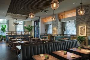 a restaurant with wooden tables and chairs and lights at The Westin Austin Downtown in Austin