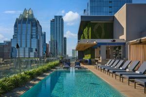 a pool on the roof of a building with lounge chairs at The Westin Austin Downtown in Austin