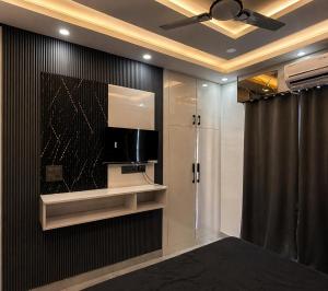 a bathroom with a television and a shower at Skyline suites in Noida