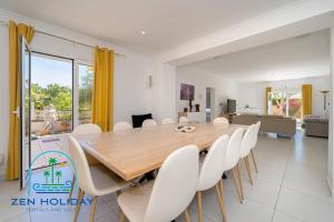 a dining room with a wooden table and white chairs at Villa Reyets 4 bed 3 bath Private Pool in Busot