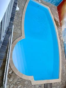 a swimming pool with blue water in a building at Le Chalet in Saint-François