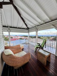 a porch with couches and chairs on a balcony at Le Chalet in Saint-François