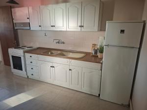 a kitchen with white cabinets and a white refrigerator at Titi's home 2 in Ofrínion