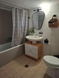 a bathroom with a sink and a toilet and a mirror at Titi's home 2 in Ofrínion