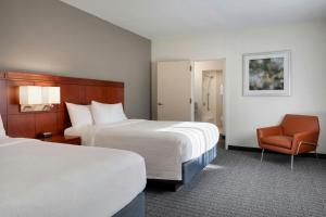 a hotel room with two beds and a chair at Courtyard by Marriott Boston Norwood/Canton in Norwood +38 photos