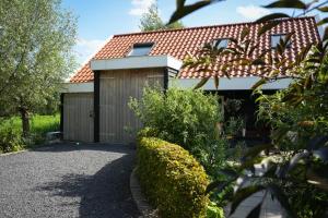 a house with a garage and a fence at De Kopstoof in Lekkerkerk
