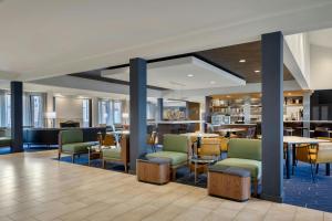 a lobby with chairs and tables and a restaurant at Courtyard by Marriott Boston Norwood/Canton in Norwood