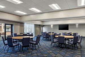 a conference room with tables and chairs and a screen at Courtyard by Marriott Boston Norwood/Canton in Norwood