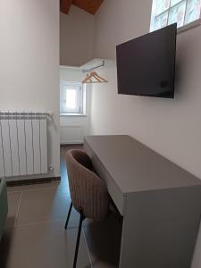 a desk with a chair and a television on a wall at B&B Belvedere in Monreale