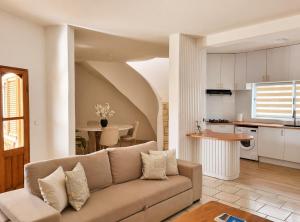 a living room with a couch and a kitchen at Casa 13 - Refúgio Salinas in Vila do Porto