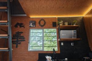 a kitchen with a microwave and a window at Lumos Experience in Guaratuba